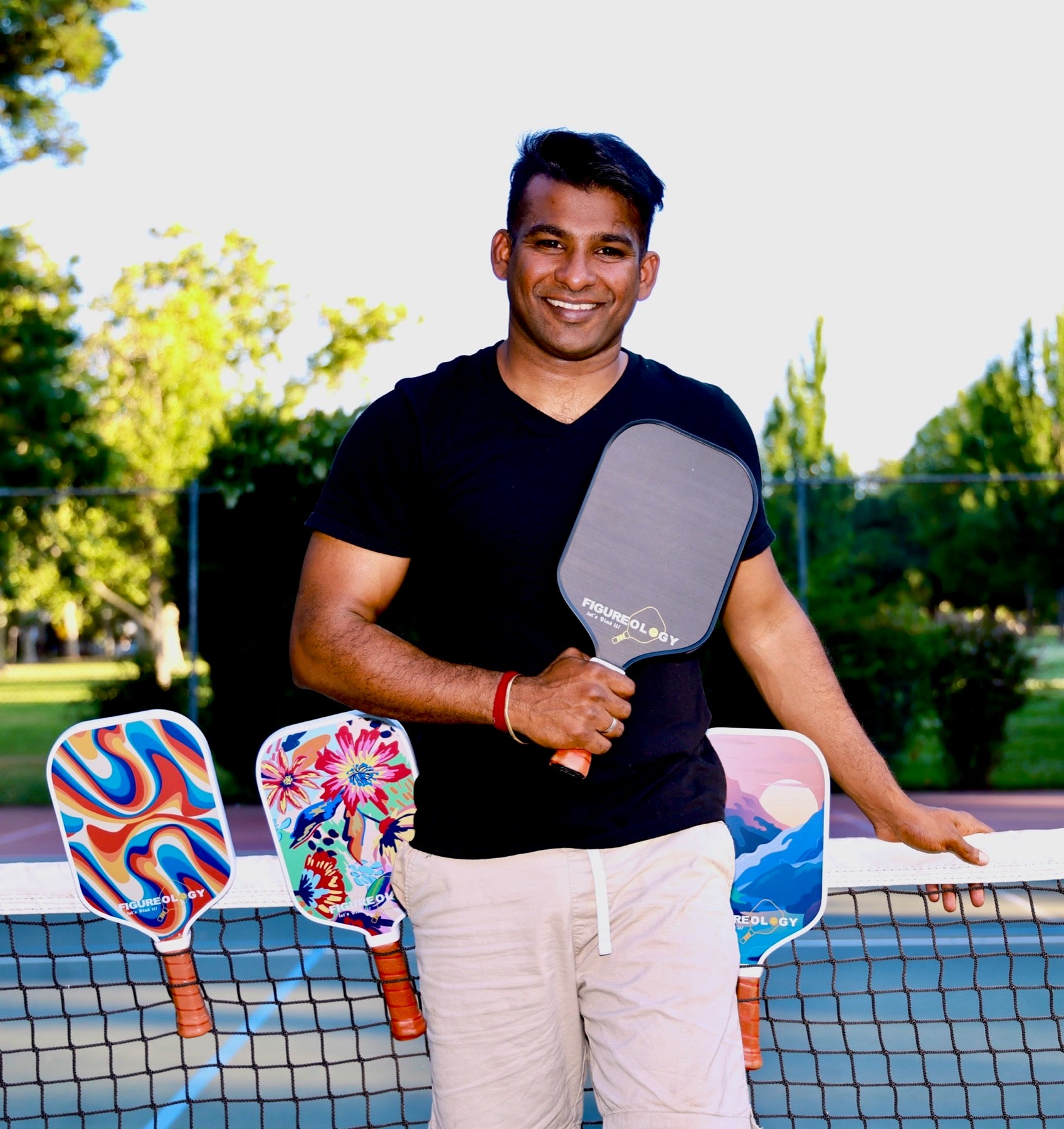 Allen Perumal holding a Figureology pickleball paddle on court