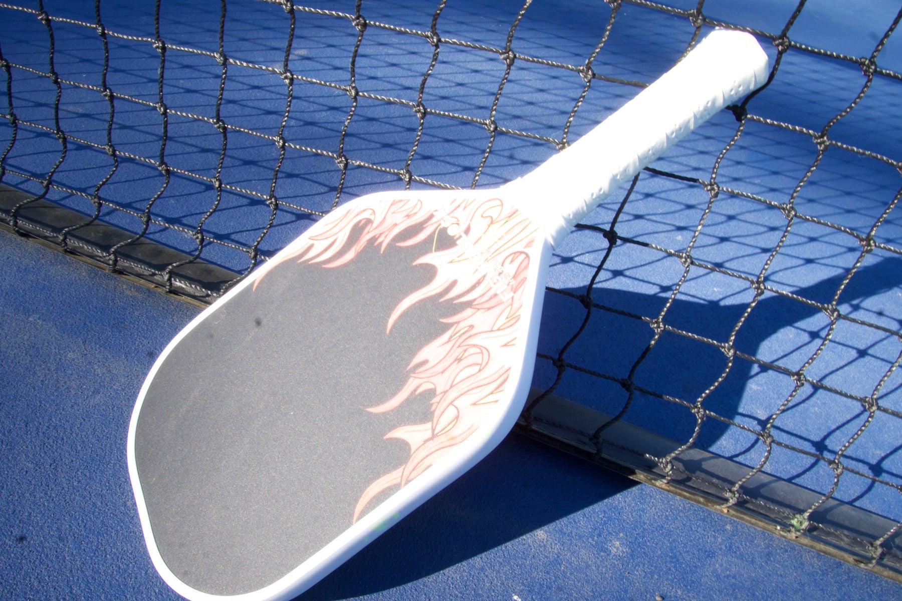 Figureology paddle close-up on a pickleball court